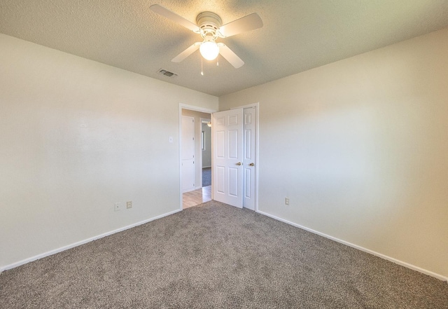 spare room with ceiling fan, carpet flooring, and a textured ceiling