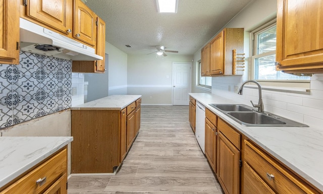 kitchen featuring sink, dishwasher, ceiling fan, light hardwood / wood-style floors, and a textured ceiling