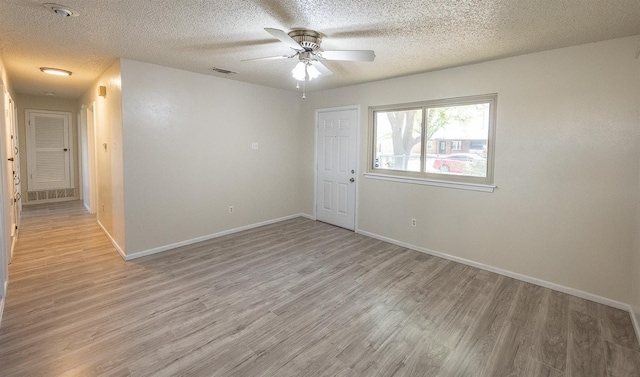 spare room with a textured ceiling, light hardwood / wood-style floors, and ceiling fan