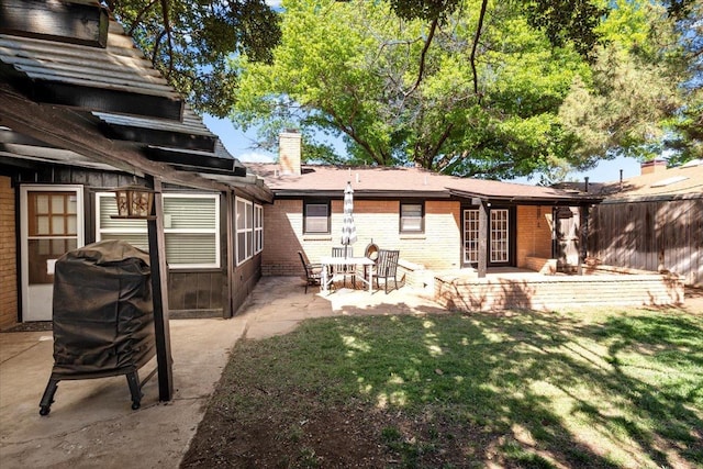 rear view of property with a patio and a yard