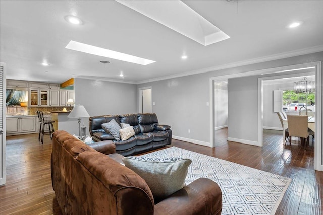 living room with crown molding, a skylight, and hardwood / wood-style floors