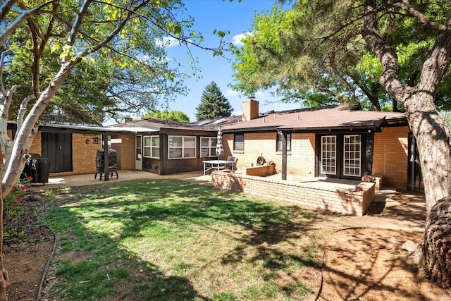 rear view of house featuring a lawn and a patio area