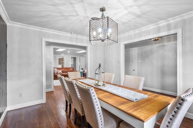 dining room with dark hardwood / wood-style flooring, ornamental molding, and an inviting chandelier