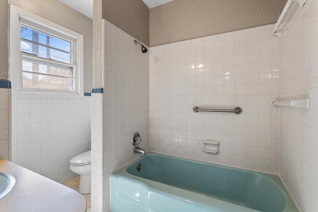 full bathroom with tile walls, sink, toilet, and tiled shower / bath