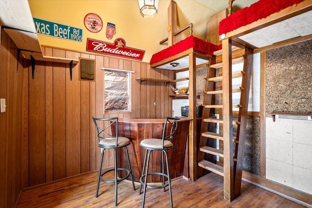 bar with wood-type flooring and wood walls