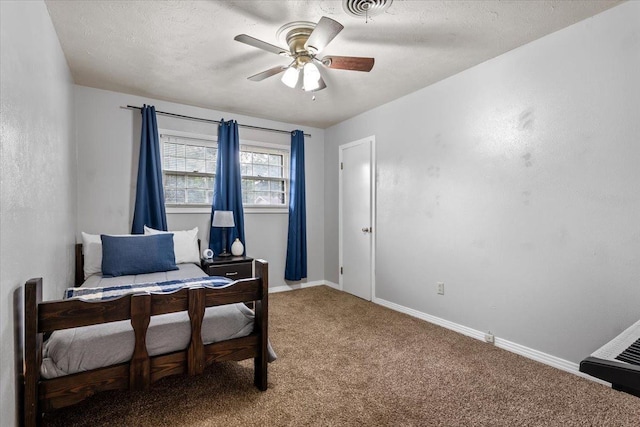 carpeted bedroom featuring ceiling fan and a textured ceiling