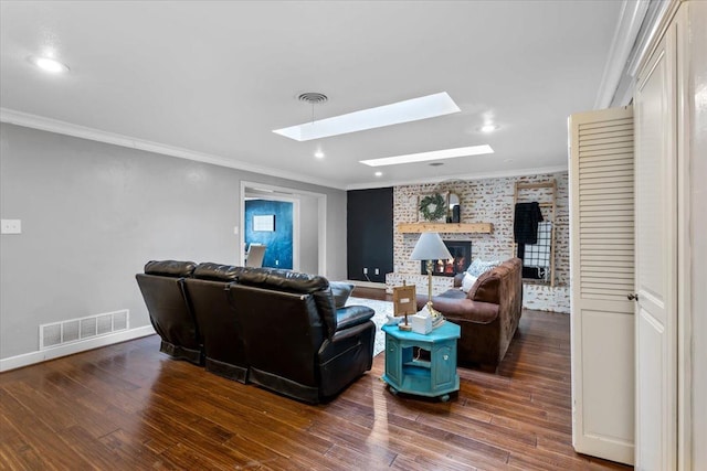 living room featuring dark wood-type flooring, ornamental molding, a fireplace, and a skylight