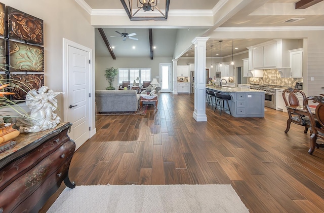 living room with crown molding, dark wood-type flooring, visible vents, and ornate columns