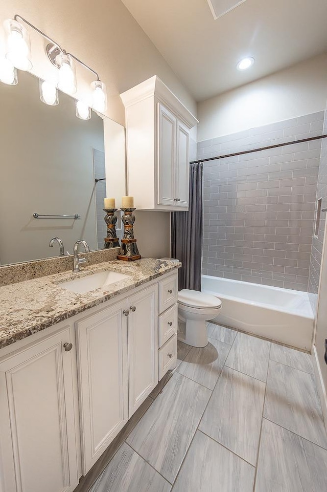 bathroom with shower / bath combo, vanity, and toilet