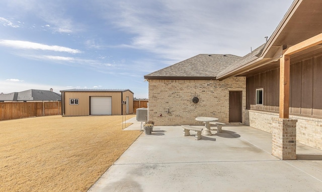 view of patio with an outbuilding, central AC, and a fenced backyard