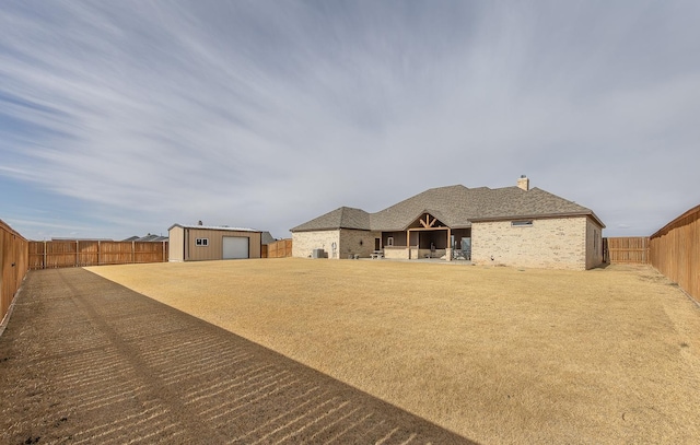 exterior space with a fenced backyard and an outdoor structure