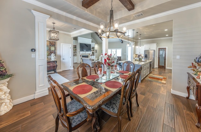 dining space with visible vents, dark wood-type flooring, crown molding, a fireplace, and a notable chandelier