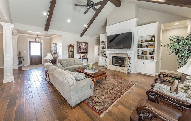 living area featuring dark wood-style floors, a stone fireplace, ornate columns, high vaulted ceiling, and beam ceiling