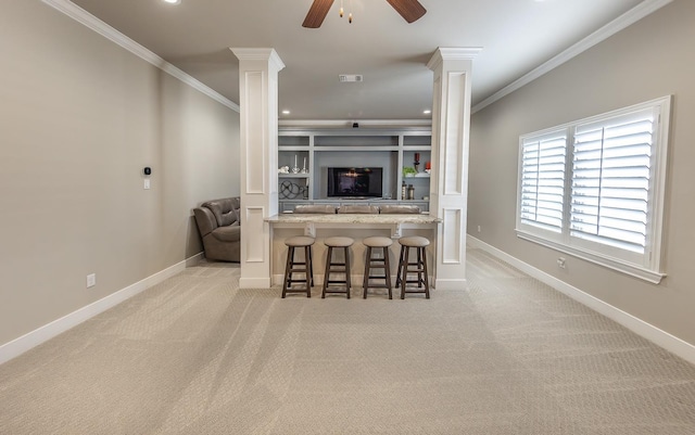 living room featuring carpet floors, decorative columns, ornamental molding, and baseboards