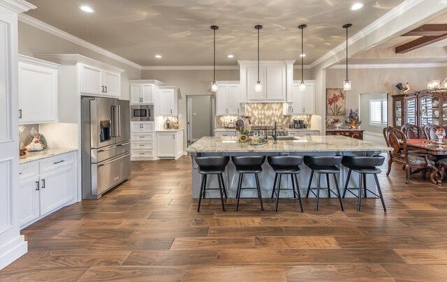 kitchen with stainless steel appliances, dark wood-type flooring, a sink, and white cabinetry