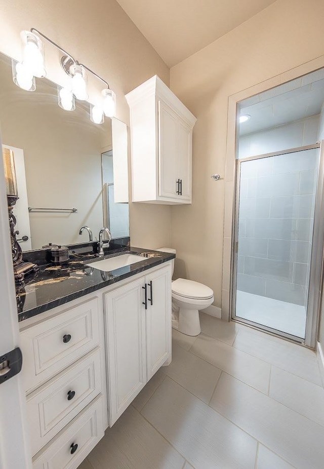 bathroom featuring tile patterned flooring, a shower stall, toilet, and vanity