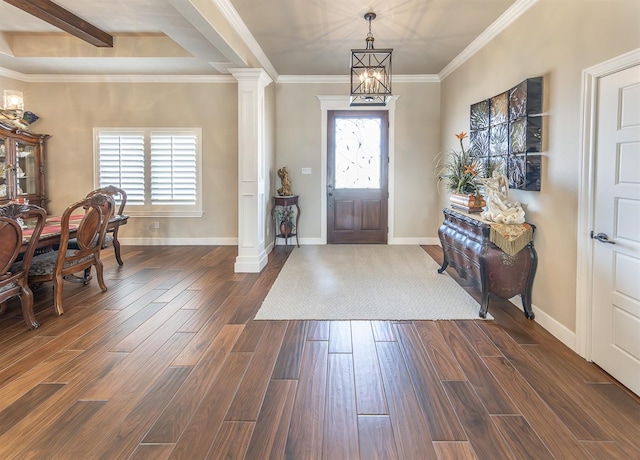 entryway with baseboards, ornamental molding, dark wood-type flooring, ornate columns, and a notable chandelier