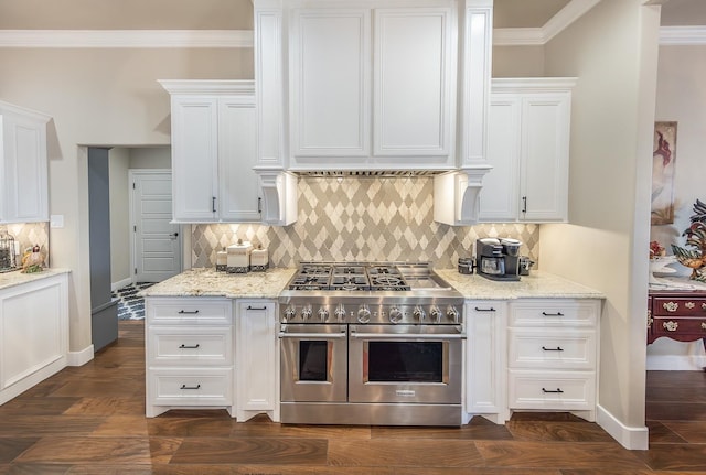 kitchen with range with two ovens, dark wood-style flooring, white cabinetry, light stone countertops, and crown molding