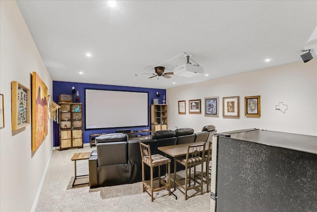 carpeted cinema room with ceiling fan