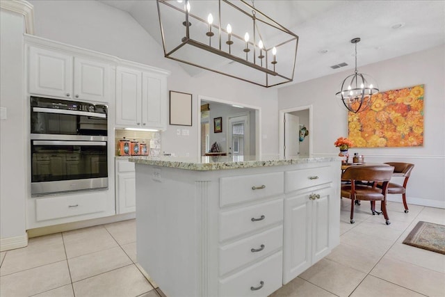 kitchen featuring a kitchen island, double oven, decorative light fixtures, white cabinetry, and light tile patterned floors