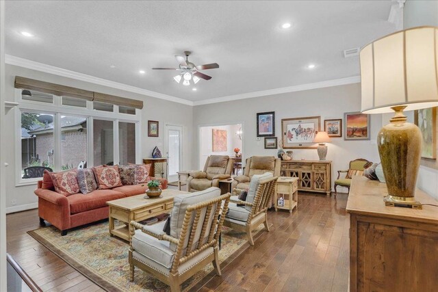 living room featuring ceiling fan, ornamental molding, and dark hardwood / wood-style flooring