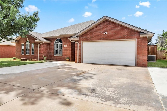 ranch-style house with a garage and central AC unit