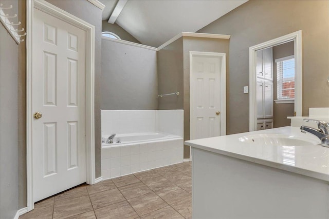 bathroom featuring a relaxing tiled tub, vanity, tile patterned flooring, and vaulted ceiling