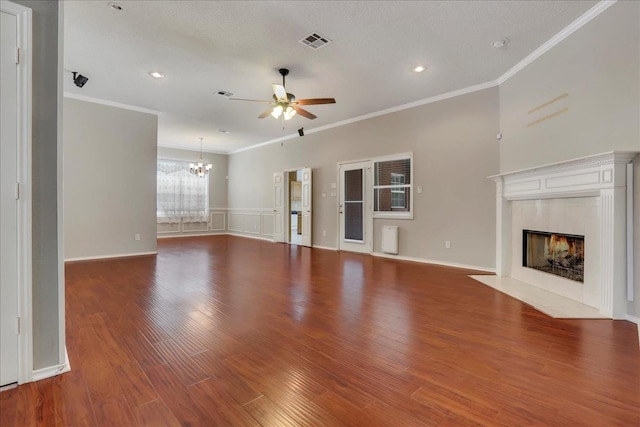 unfurnished living room featuring crown molding, hardwood / wood-style flooring, a fireplace, and ceiling fan with notable chandelier