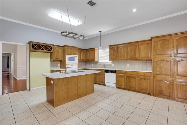 kitchen with sink, a center island, hanging light fixtures, light tile patterned floors, and white appliances