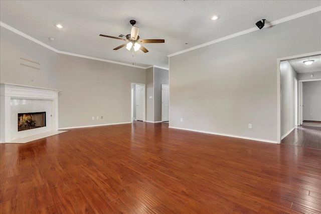 unfurnished living room with dark hardwood / wood-style flooring, crown molding, a premium fireplace, and ceiling fan