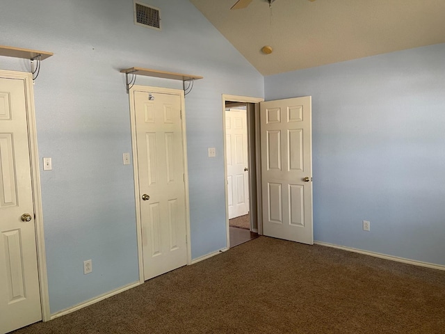 unfurnished bedroom with lofted ceiling and dark carpet