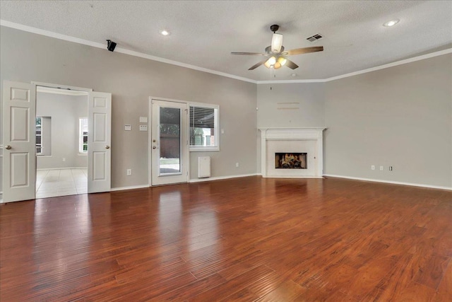 unfurnished living room featuring crown molding, ceiling fan, hardwood / wood-style floors, and a textured ceiling