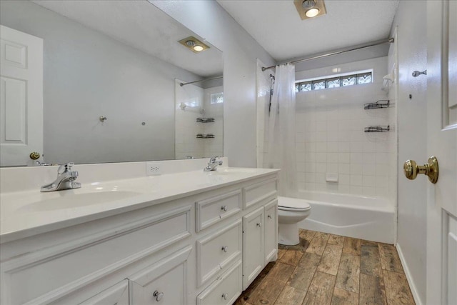 full bathroom featuring wood-type flooring, vanity, shower / tub combo, and toilet