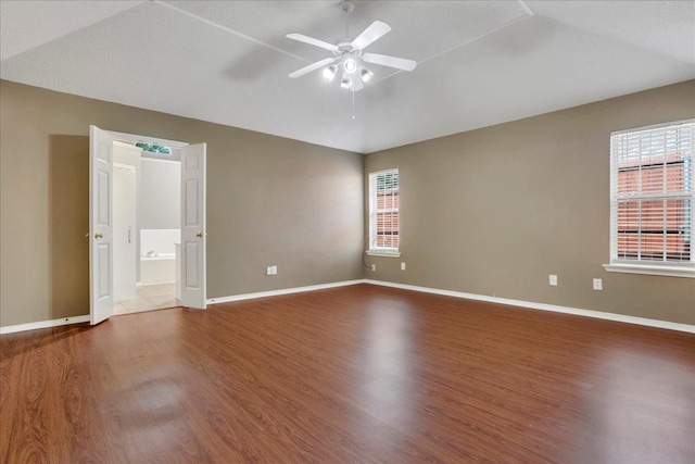 unfurnished bedroom featuring ceiling fan, lofted ceiling, hardwood / wood-style floors, and ensuite bath