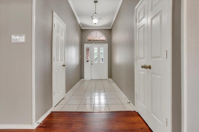 doorway to outside with ornamental molding and light wood-type flooring