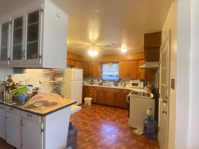 kitchen featuring dark parquet floors, sink, ceiling fan, kitchen peninsula, and white appliances