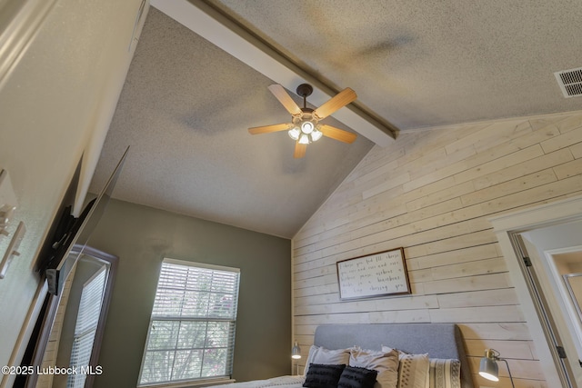 1310 Yorkshire Ave, Wolfforth, TX 79382 - bedroom featuring ceiling fan, a textured ceiling, visible vents, wood walls, and vaulted ceiling with beams