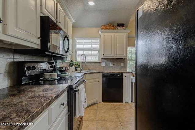 1310 Yorkshire Ave, Wolfforth, TX 79382 - kitchen with a textured ceiling, light tile patterned floors, a sink, backsplash, and black appliances