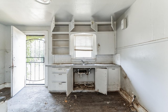 kitchen featuring a healthy amount of sunlight, sink, and white cabinets