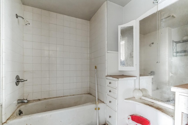 bathroom with tiled shower / bath and vanity