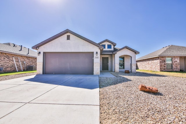 view of front of home featuring central AC and a garage