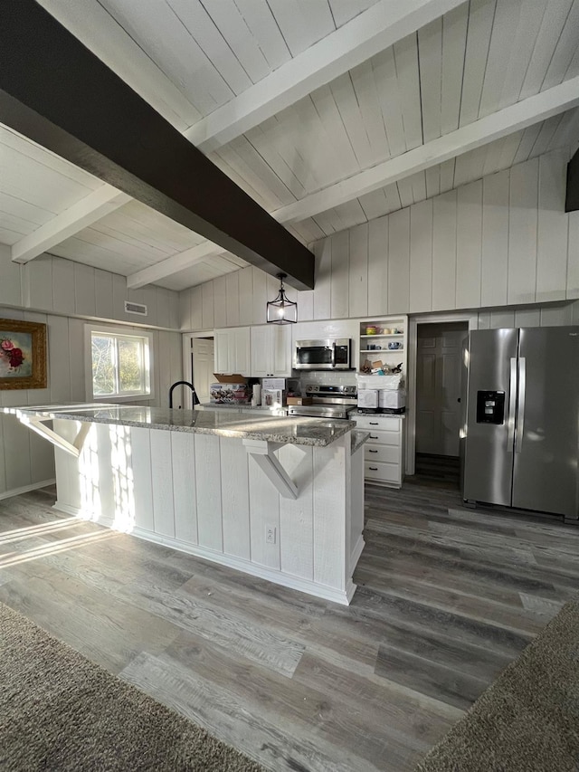 kitchen with white cabinetry, light stone countertops, dark wood-type flooring, and stainless steel appliances