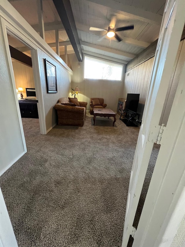 sitting room with carpet, vaulted ceiling with beams, and wooden walls