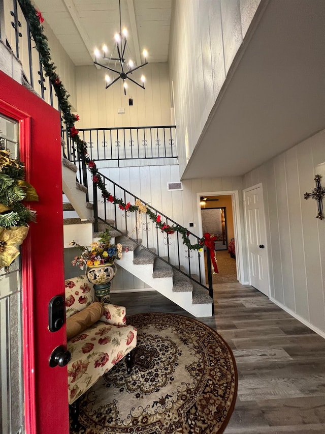 staircase with hardwood / wood-style flooring and a notable chandelier