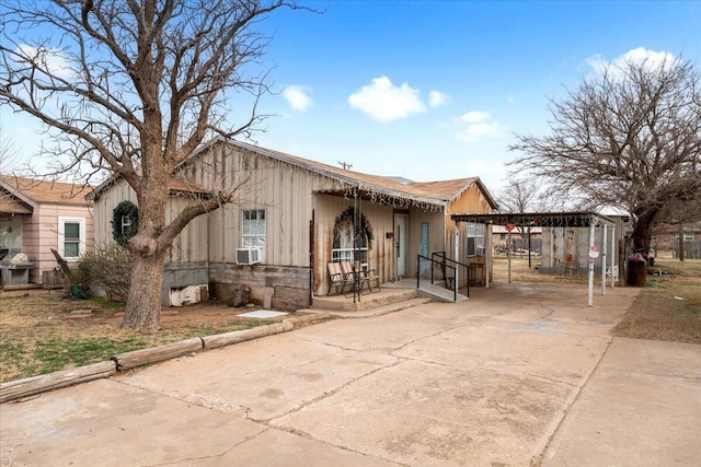 view of front facade with cooling unit, a detached carport, and concrete driveway