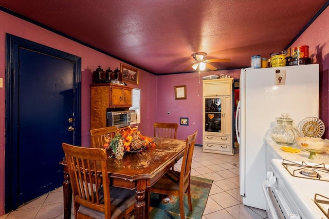 dining area with light tile patterned floors, a textured ceiling, and a ceiling fan