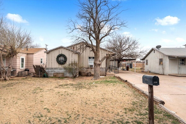 view of front of home with concrete driveway and a carport