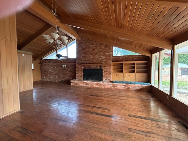 unfurnished sunroom with a notable chandelier, a fireplace, lofted ceiling with beams, and wooden ceiling