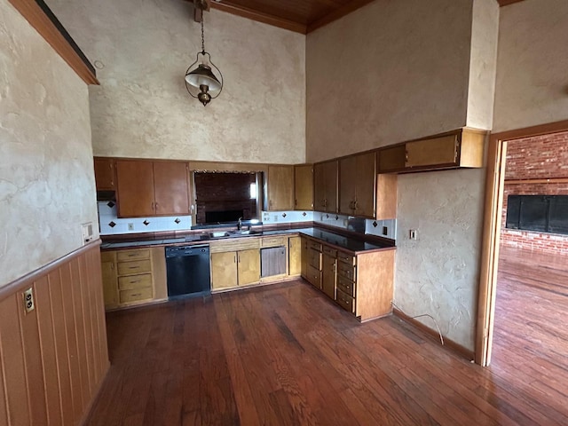 kitchen featuring sink, a towering ceiling, dark hardwood / wood-style floors, and dishwasher