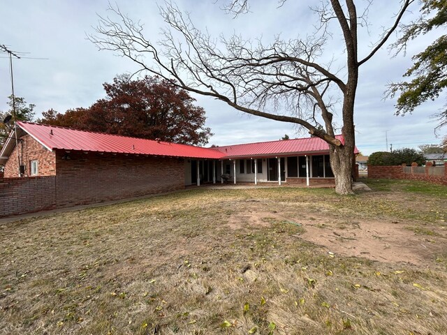 rear view of property featuring a lawn